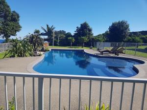 a swimming pool with a fence around it at Te Kaha Beach Hotel in Te Kaha