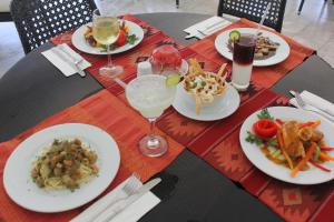 a table with plates of food and drinks on it at Hotel Aldea del Bazar & Spa in Puerto Escondido