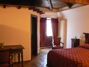 a bedroom with a bed and a table and a window at Residence Il Palazzo in Santo Stefano di Sessanio