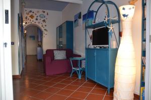 バイア・ドミツィアにあるVilla Ferreroのリビングルーム(青いキャビネット、テレビ付)