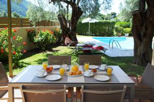 a table with food and orange juice on top of it at Kydonies Villas in Lefkada Town