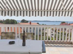 a table with two wine glasses on a balcony at Apartments & Rooms Nikolić in Fažana