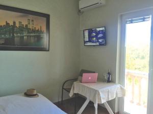 Zimmer mit einem Tisch und einem Laptop darauf in der Unterkunft Apartmani Suric in Privlaka