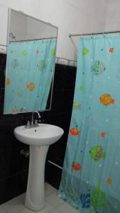 a bathroom with a sink and a shower curtain at Yellow House Vacation Rental in Subic