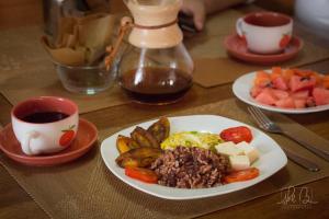 a table with a plate of food and a cup of coffee at Casa Lucia in Managua
