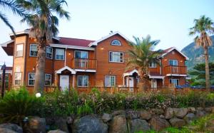 a large house with palm trees in front of it at Sweetsalt in Seogwipo