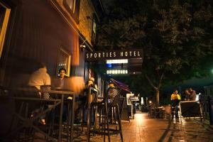 un grupo de personas sentadas en un bar por la noche en Sporties Hotel en Launceston