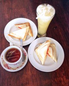 een tafel met twee borden toast en een drankje bij Brother Bungalow in Gili Trawangan