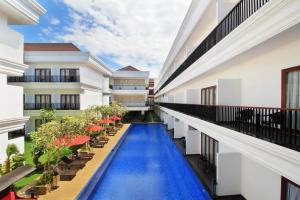 a corridor of a building with a swimming pool at Grand Palace Hotel Sanur - Bali in Sanur