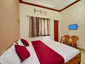 a bedroom with a large bed with red pillows at Surya Inn in Konārka