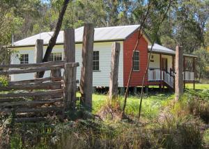 a red and white house with a fence at Neds Cabin in Amiens