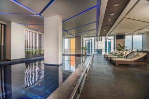 望加錫的住宿－Arthama Hotels Makassar，酒店大堂设有游泳池和椅子