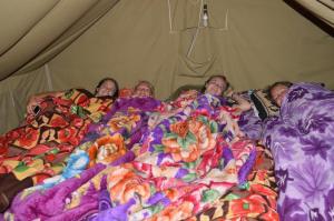 a group of people laying in bed under blankets at Dhanaulti Camp Homes Retreat in Dhanaulti