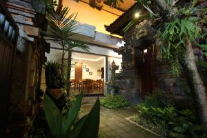a courtyard with plants and a dining room in a house at Surya Inn in Kuta
