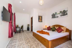 a bedroom with a bed and a flat screen tv at Siem Reap Friendly House in Siem Reap