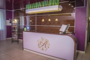 a restaurant with a white counter and purple walls at Aura Hotel-ZURO in Ulyanovsk