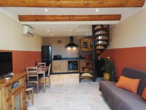 a living room with a kitchen and a spiral staircase at Chambres d'Hôtes La Chrysalide in Loriol-du-Comtat