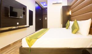 a bedroom with a bed with a tv on the wall at Vibhav Grand in Haridwār +16 photos