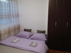 een slaapkamer met een bed met paarse lakens en kussens bij Apartman Sutjeska in Tjentište