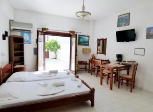 a bedroom with a bed and a dining room at White House Hotel-Apart in Karpathos