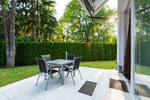 eine Terrasse mit einem Tisch und Stühlen auf einer Veranda in der Unterkunft Apartments Patricia in Bled