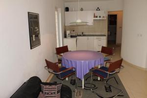 una cocina con mesa púrpura y sillas en Apartments Vila Marica, en Rabac