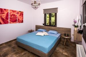 タブロニティスにあるMarelia Luxurius Apartmentのベッドルーム(青いベッド1台、窓付)