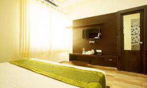 a bedroom with a bed and a television in it at Vibhav Grand in Haridwār