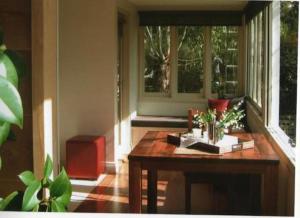 a living room with a table and a window at Hollyhock in Macedon