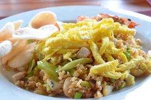 a white plate of food with rice and vegetables at Cocotinos Sekotong Lombok in Sekotong