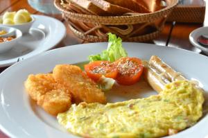 a plate of food with eggs and tomatoes on a table at Cocotinos Sekotong Lombok in Sekotong