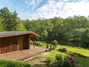 a cabin with a wooden deck next to a river at Domek w Dolinie Drwęcy in Lubicz