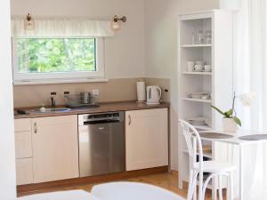 uma cozinha com armários brancos, um lavatório e uma janela em Domek w Dolinie Drwęcy em Lubicz