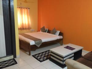 una camera con un letto con una parete arancione di Hotel Arham Inn a Rānchī