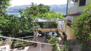 a balcony of a house with a table and chairs at Apartments Andrea in Baška