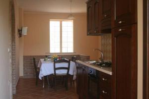 a kitchen with a table with chairs and a window at B&B del Castagneto in San Marco Argentano