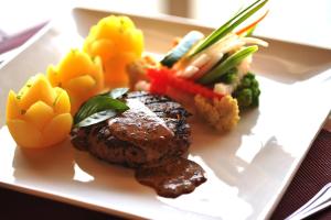 a plate of food with meat and vegetables on a table at Cocotinos Sekotong Lombok in Sekotong