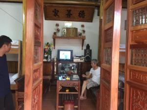 un homme assis dans une pièce avec télévision dans l'établissement Hung Anh Homestay, à Ninh Binh