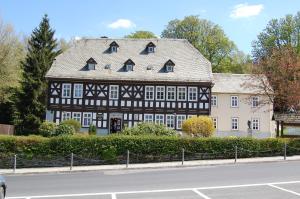 an old black and white building on the side of a street at Ferienwohnungen Chris Stephan in Oberweißbach