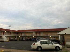 a white car parked in a parking lot in front of a motel at Scottish Inn Near the Falls and Casino in Niagara Falls