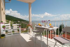 a balcony with a table and chairs and a view of the ocean at Ičići Bellevue in Ičići
