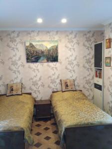 ein Schlafzimmer mit 2 Betten und einem Wandgemälde in der Unterkunft Dadu's Apartment in Tbilisi City