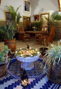 a large living room with a large fountain with plants at Riad Dalia in Marrakesh