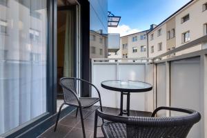 - Balcón con mesa pequeña y 2 sillas en Apartment Royal I, en Białystok