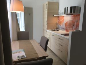 a kitchen with a wooden table and a dining room at Apartments42 in Klosterneuburg