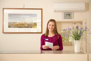 a woman standing at a counter in a room at Welcome Inn 277 in Adelaide