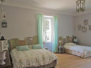 a bedroom with two beds and a window at Le Manoir aux Douves in Bazoges-en-Paillers