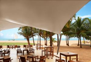 a restaurant on the beach with tables and chairs at Jetwing Beach in Negombo