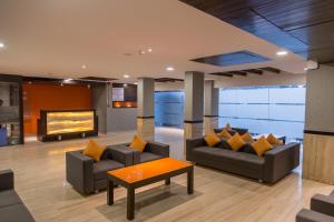 ein Wohnzimmer mit zwei Sofas und einem Fernseher in der Unterkunft Ginger Ahmedabad, Satellite in Ahmedabad
