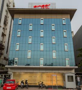 un edificio azul con gente en bicicleta delante de él en Ginger Ahmedabad, Satellite, en Ahmedabad